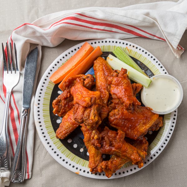 Plate of Ribs on the Run BBQ chicken wings with carrots, celery, and ranch dressing.