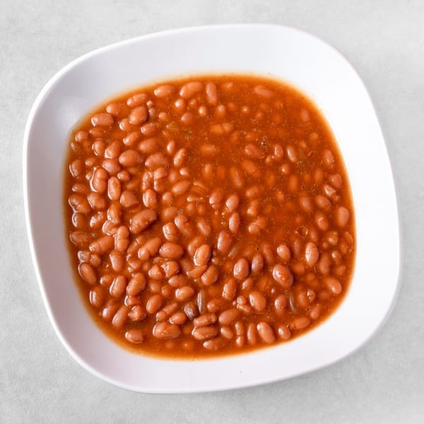 Close-up overhead view of a white bowl filled with Ribs on the Run's baked beans.